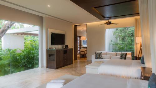 a bedroom with two beds and a television in it at Chablé Yucatan in Chocholá