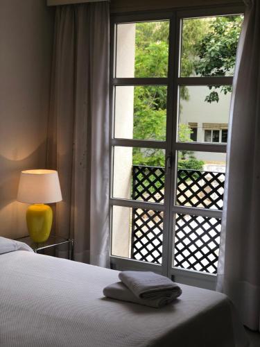 a bedroom with a window with a bed and a lamp at NUEVA CAZORLA BELLA VISTA in Cazorla