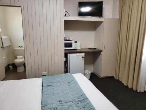 a room with a bed and a microwave at Windsor Hotel Motel Dalby in Dalby