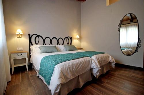 a bedroom with a large bed and a mirror at Hotel Rural San Giles in Jarandilla de la Vera