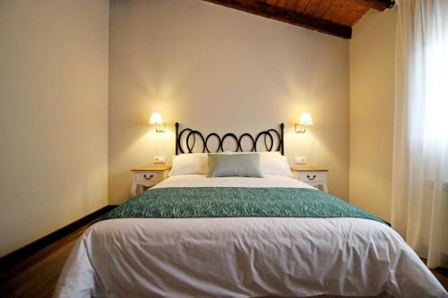 a bedroom with a large bed with a green blanket at Hotel Rural San Giles in Jarandilla de la Vera