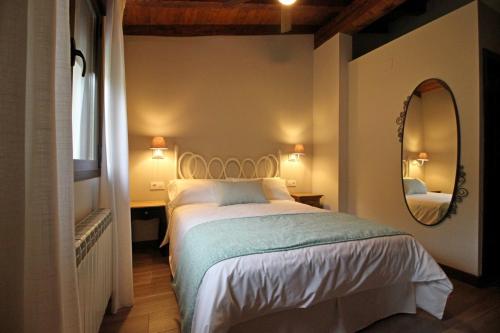 a bedroom with a large bed and a mirror at Hotel Rural San Giles in Jarandilla de la Vera