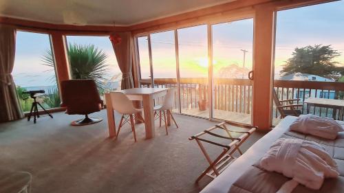 a room with a bed and a table and chairs at Kaka Point Spa Accommodation - Catlins in Kaka Point