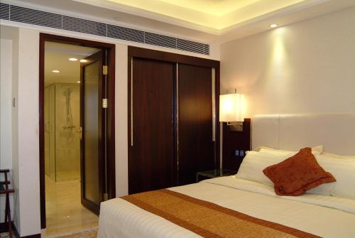 a bedroom with a bed and a walk in shower at Guangdong Hotel-Free Shuttle & Registration Counter Service during Canton Fair in Guangzhou