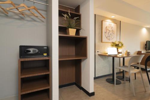 a room with a desk and a table in a room at The Home Hotel SHA in Bangkok