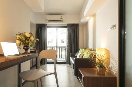 a living room with a couch and a table at The Home Hotel SHA in Bangkok