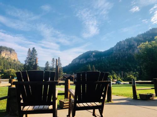 two chairs sitting on a patio with mountains in the background at Spearfish Canyon Lodge in Spearfish