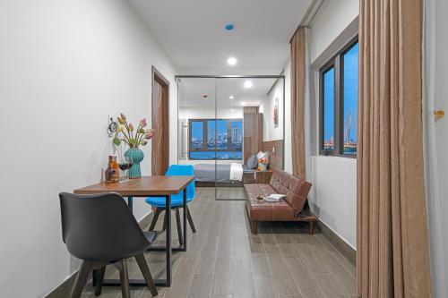 a living room with a table and chairs and a couch at TIDITEL Hotel and Apartment in Da Nang