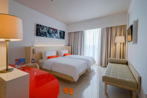 a hotel room with a large bed and a desk at HARRIS Hotel and Conventions Denpasar Bali in Denpasar