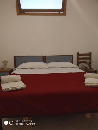 1 dormitorio con 1 cama grande con manta roja en Casa Totano, en Canneto