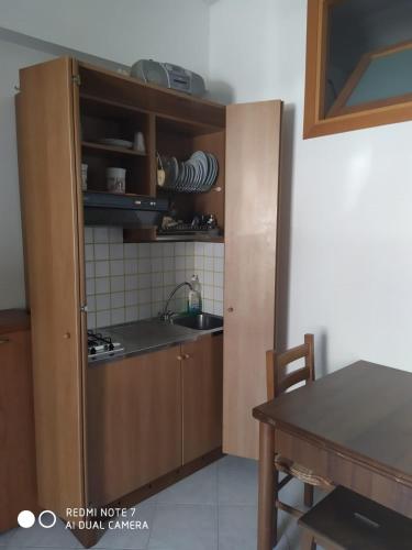 a kitchen with wooden cabinets and a sink and a table at Casa Totano in Canneto