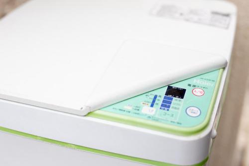 an electronic device sitting on top of a refrigerator at NexStay HOUSE Osaka West in Osaka