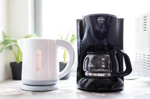 a coffee maker and a coffee mug on a counter at NexStay HOUSE Osaka West in Osaka