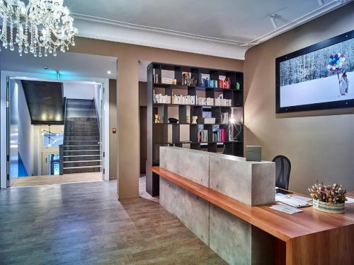 a lobby with a reception desk and a tv on the wall at Bellevue-Terminus - Urban Lifestyle Hotel in Engelberg