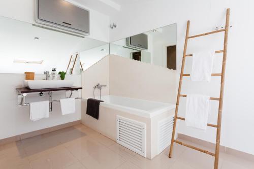 a white bathroom with a sink and a mirror at Sunset Boutique Duplex in Calonge