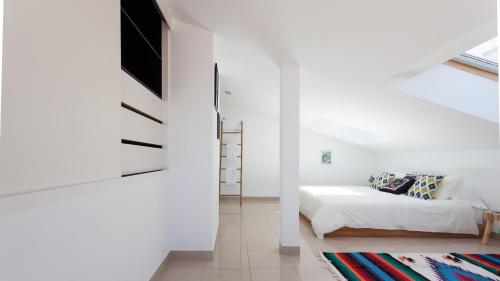 a white room with a bed and a tv at Sunset Boutique Duplex in Calonge