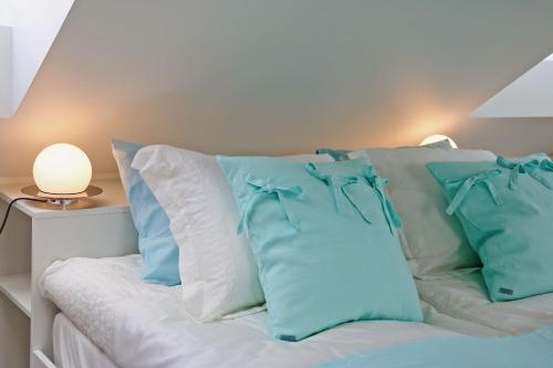 a bed with blue and white pillows on it at Lavender Village in Kiemeliai