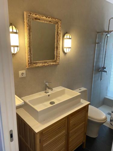 a bathroom with a sink and a toilet and a mirror at Sea Views Penthouse in Sitges
