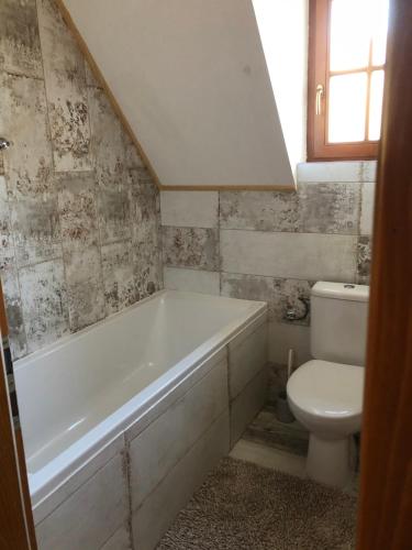 a bathroom with a white tub and a toilet at Chatka Katka in Liptovský Mikuláš
