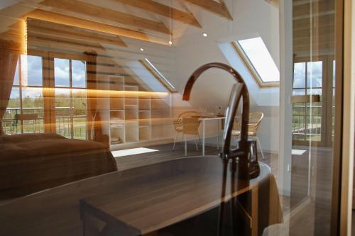 a kitchen with a sink and a table and windows at Lavender Village in Kiemeliai