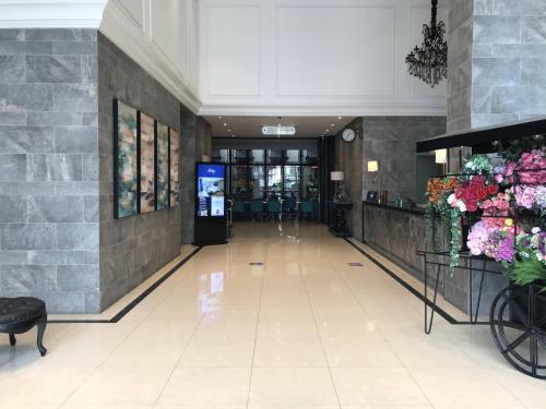 a hallway of a building with a lobby with flowers at Ashley Sabang Jakarta in Jakarta