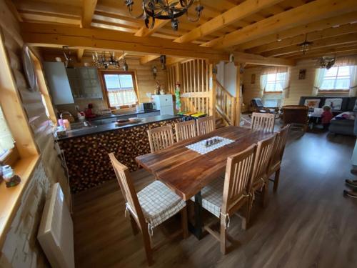 a kitchen and dining room with a wooden table and chairs at Chatka Katka in Liptovský Mikuláš