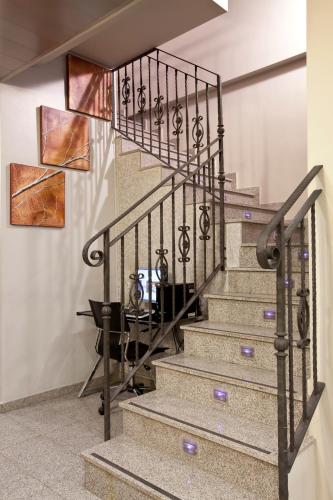 a staircase with a wrought iron railing and a table at La City Estación in Alicante
