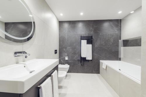 een witte badkamer met een wastafel en een toilet bij Mamaison Residence Diana in Warschau