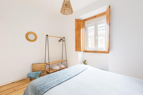 ein Schlafzimmer mit einem Bett und einem Fenster in der Unterkunft Feel Home in this Stunning Renovated Nest in Graça in Lissabon