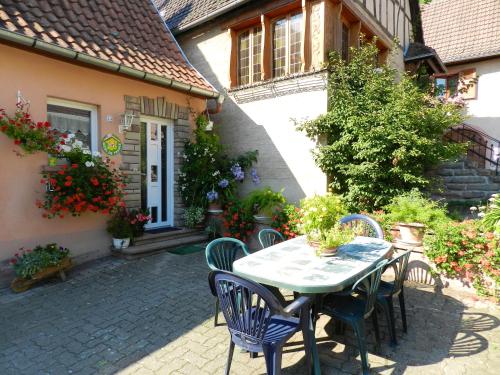 a patio with a table and chairs in front of a house at Maison de 2 chambres avec jardin clos et wifi a Triembach au Val in Triembach-au-Val