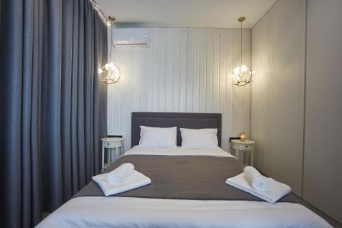 a bedroom with a large bed with two towels on it at Gagarin Plaza Luxury Sea View Apartments in Odesa
