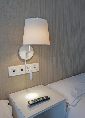 a lamp on a table next to a bed at La Lonja in Alicante