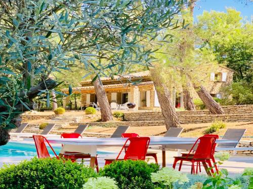 a table and chairs next to a pool at Zen et Chic, juste à coté de la Bastide de Marie in Ménerbes