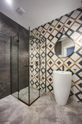 a bathroom with a shower and a toilet and a mirror at Gagarin Plaza Luxury Sea View Apartments in Odesa