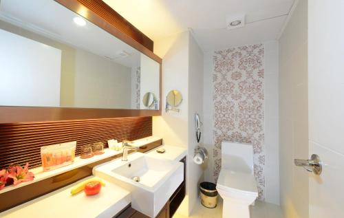 a bathroom with a sink and a toilet and a mirror at Hotel Metropole in Macau