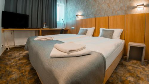 pokój hotelowy z dużym łóżkiem i ręcznikami w obiekcie Hotel Aréna w Koszycach