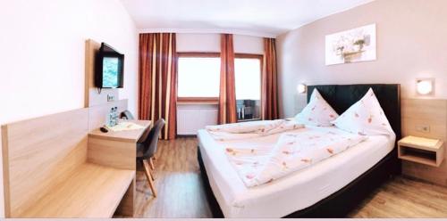 una camera d'albergo con letto e scrivania di Hotel Sonnhof a Wiesing