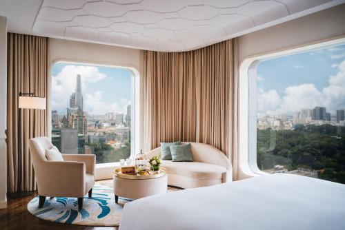 a hotel room with a bed and a large window at Hotel Des Arts Saigon Mgallery Collection in Ho Chi Minh City