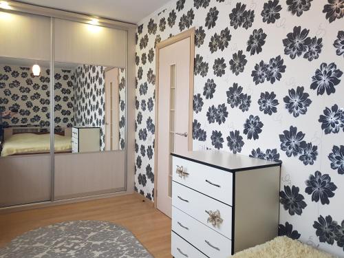 a bedroom with a dresser and a mirror at Apartment on Zoe Kosmodemyanskoy in Pinsk
