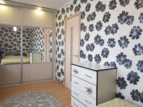 une chambre avec une commode et un miroir dans l'établissement Apartment on Zoe Kosmodemyanskoy, à Pinsk