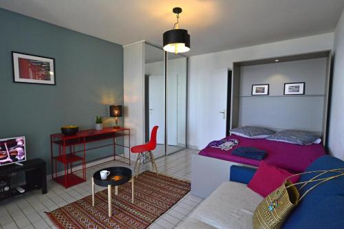 ein Schlafzimmer mit einem Bett, einem Tisch und einem Stuhl in der Unterkunft Studio de 33 m2, vue et bord de mer, parking in La Grande-Motte