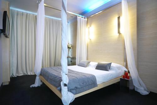 a bedroom with a bed with white curtains at Hotel Europa in Palazzolo sullʼOglio