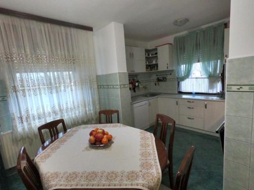 a kitchen with a table with a bowl of fruit on it at Moj salaš in Novi Sad