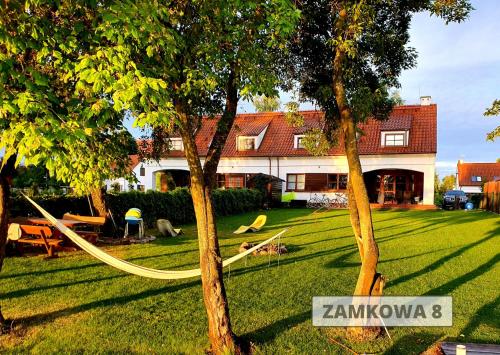 a yard with two trees and a house at ApartView na Mazurach "Osada Zamkowa" by Rent like home in Pasym