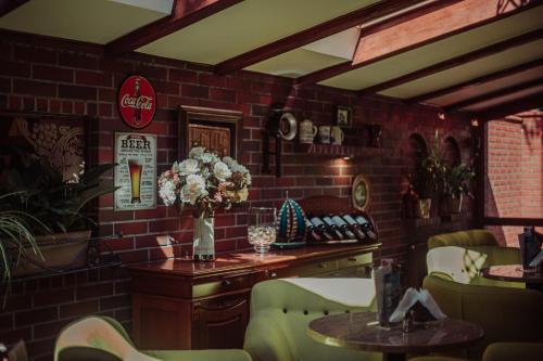 a restaurant with a brick wall and a table with flowers at Dworek Morski SPA & Wellness in Mielno