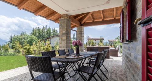 a patio with a table and chairs on a patio at ALTIDO Superb Villa with Tennis Court, Garden and BBQ area in Valle