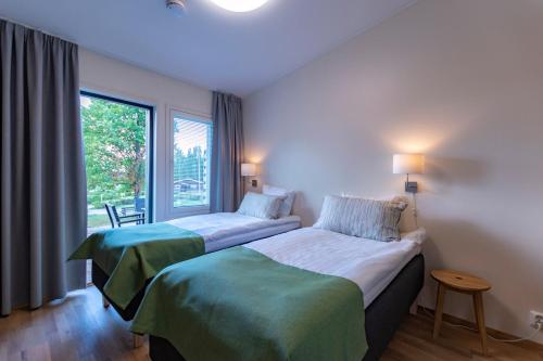 two beds in a room with a window at Lohja Spa & Resort in Karjalohja