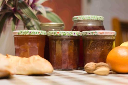 a group of four jars of jam next to an orange at La Fermette Champenoise in Jonquery