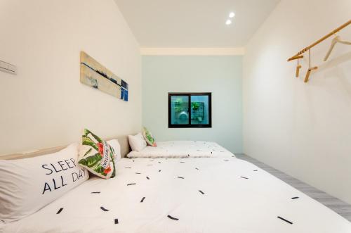 台南的住宿－樹舍包棟民宿開山館，白色的卧室设有床和窗户