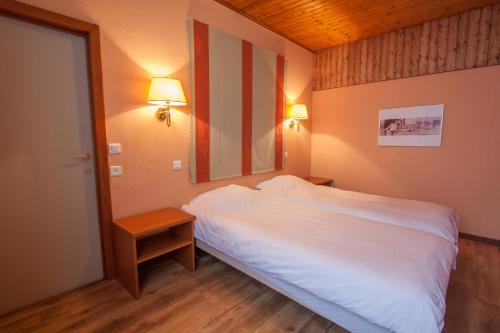 sypialnia z dużym białym łóżkiem i lustrem w obiekcie GÎTE LA MARQUISETTE w mieście Houyet